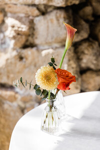bud vase with orange roses and yellow flowers