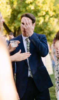 Groom excitedly showing off his new ring to his friends at his outdoor cocktail hour at Stone Mountain Lodge in Lyons, Colorado.