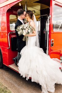 Bride and groom sharing a romantic kiss on London Bus