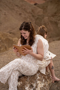 Two brides exchanging vows at sunrise at Zabriskie Point in Death Valley, with the golden, rugged hills of the desert stretching out behind them