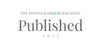 A badge symbolizing publication in the Photograp{HER} Magazine .