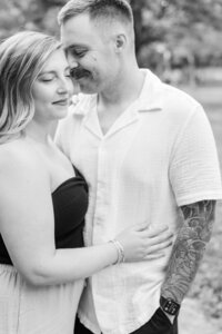 Engaged couple embrace during their engagement session at Anchorage Trail in Louisville