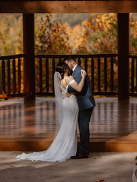first kiss between bride and groom as husband and wife at a pavilion at brothers lodge in the Smoky Mountains captured by gatlinburg photographers 
