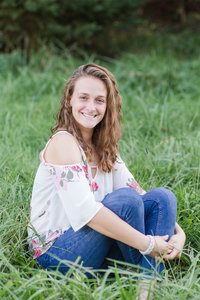 high school senior girl sitting in grass with her knees curled up to her chest with her arms wrapped around her legs, perry high school senior, photographed by Jamie Lynette Photography canton senior photographer