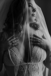 Artistic black and white boudoir portrait by Sharlie Faye, emphasizing raw beauty and emotion.