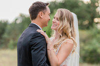 Bride and Groom staring into each others eyes while bride has her hand on his shoulder.
