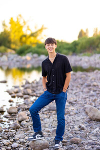 Boy wearing blue jeans next to shoreline for Spokane photos