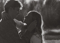 A couple holding hands on top of a parking garage, running together.
