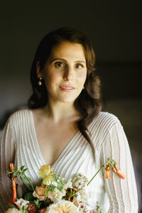Bride in vintage dress poses with bouquet on her wedding day at Harvest Inn in St. Helena