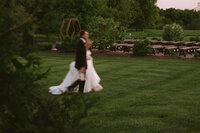 groom helps bride put in heels before wedding ceremony