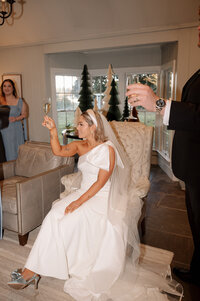 A bride and groom walk down the aisle holding their hands in the air, celebrating their marriage together.