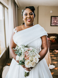 bride holding a bouquet in a hotel suite