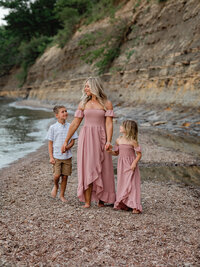 mom and two children walking on beach for family photos