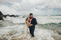 bride and groom hugging in ocean