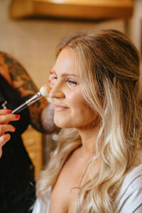 Libby, a licensed esthetician applying makeup to a client.