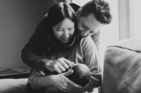 black and white photo of family with newborn