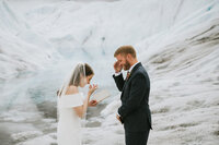 couple wiping away tears during their ceremony on a glacier during their alaska glacier elopement