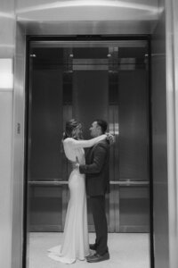 The bride and groom strike a pose in the elevator during their elopement, capturing intimate moments filled with love