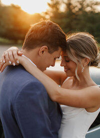 A bride and groom posing for a photo in the sunlight