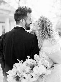black and white photo of bride and groom smiling looking at each other