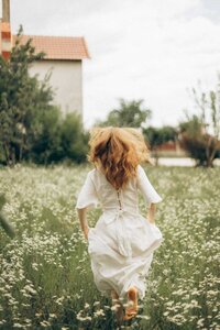 Woman in white dress running in fields