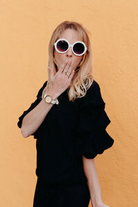 A woman member of the LIVE BIG Collective posing confidently with sunglasses on 