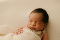 newborn photographer capturing baby wrapped up in studio