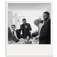 Groom and groomsmen laugh while getting ready for the wedding