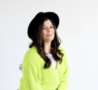 Sarah Greener wearing highlighter yellow sweater and black hat