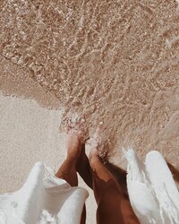 Image showcasing bare feet in shallow, clear water, evoking a sense of natural purity and tranquility, aligning with the wellness experience of The Complexion Club, a skincare club with an aesthetic-forward website.