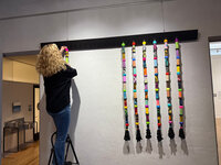 woman-on-ladder-installing-art