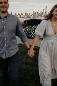 A couple holding hands with a city view in the background