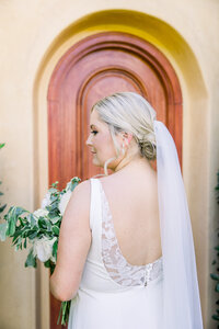 A bride looks over her shoulder at her wedding in Paso Robles