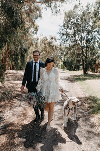 bride and groom walking their dog to the golf park for portraits