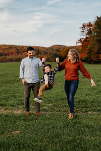 A touching family portrait capturing unity and love, framed by the golden hues of a Vermont fall field.