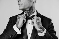 Groom adjusting bowtie before the ceremony — timeless wedding detail photography by The Proper Collective in Des Moines.