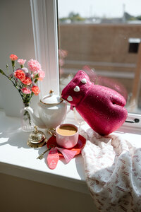 Branded morning setup with flowers, tea set, coffee, and a pink boxing glove purse, representing Sugarpunch Marketing®'s bold and creative brand.