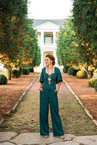 Woman wearing green jumpsuit posing for portrait