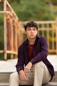 Senior boy sitting on a staircase with rusted posts in Boise.