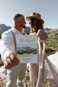 Couple holding their wedding announcement card