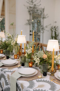 A man leans his head against his fiancé while holding hands. She's looking at the camera smiling. They look like they are in a framed photo. 