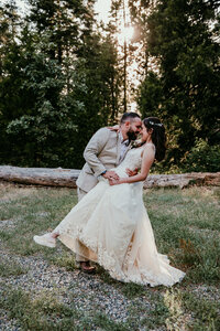 Couple sharing an intimate moment in the mountains, embracing with a scenic river and rugged landscape in the background.