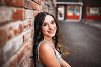 Senior Photography, girl leaning against an old brick wall