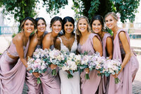 Bride Squad with their bouquets posing for a photo with joyful smiles.