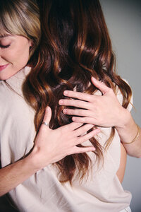 Two women stand together in front of a white wall, reflecting on their journey of self-awareness and therapy challenges.
