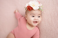 3 months old baby girl smiling wearing pink romper