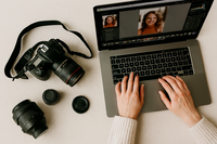 Flat lay of essential self-portrait photography gear including camera equipment, lenses, and creative tools arranged on a neutral-toned desk for content creators and photographers.