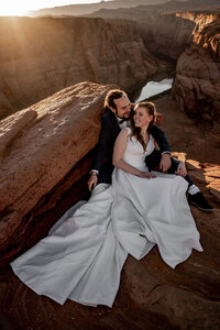 A couple eloping at Horseshoe Bend, exchanging vows at the edge of the canyon, with only the natural beauty of the desert landscape as their witness.
