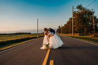 ohio bride and groom dancing in the middle of the road at sunset
