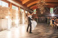groom lifts bride up during first dance